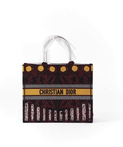 Front view of the Christian Dior Book Tote with a yellow and burgundy print