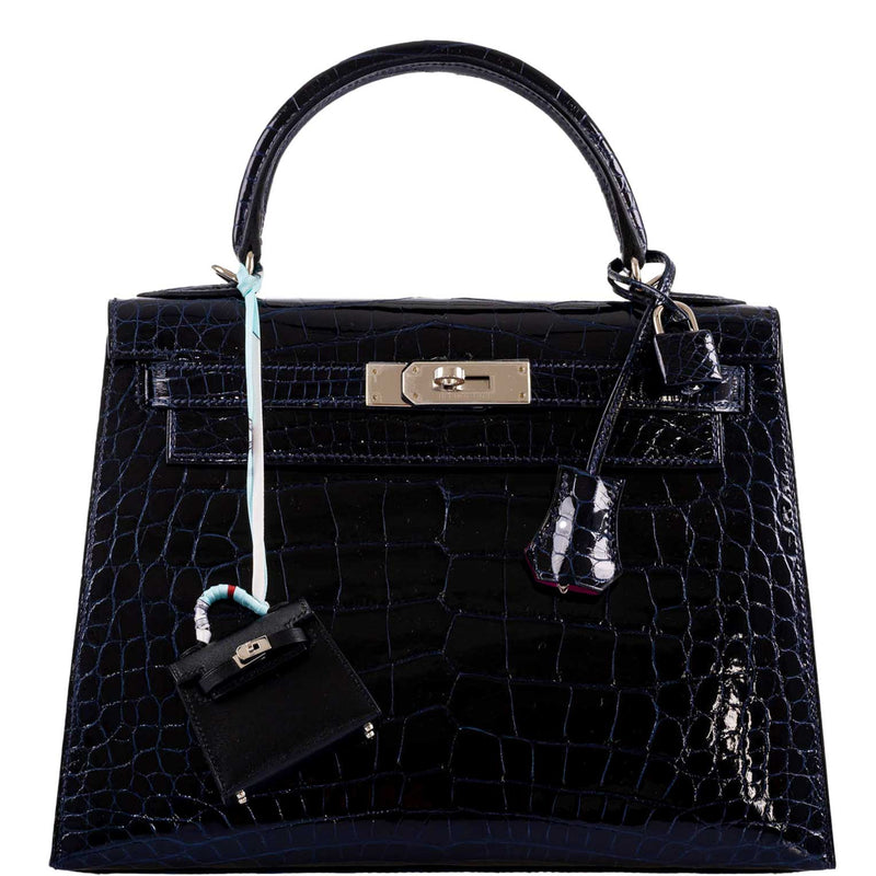 The Hermes Kelly 28 Verso in Blue Marine Crocodile on a table