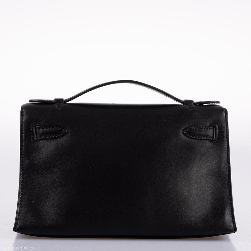 Close-up of palladium hardware and handle on Hermes Kelly Mini Pochette black Swift.

