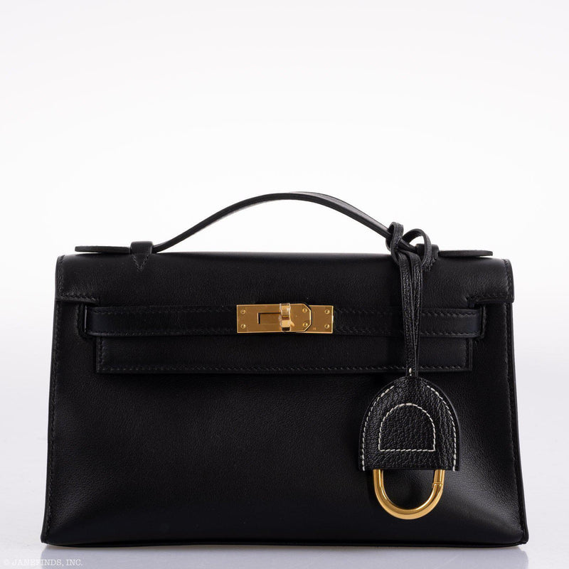The Hermes Kelly Mini Pochette being carried as a clutch, showcasing its sleek profile