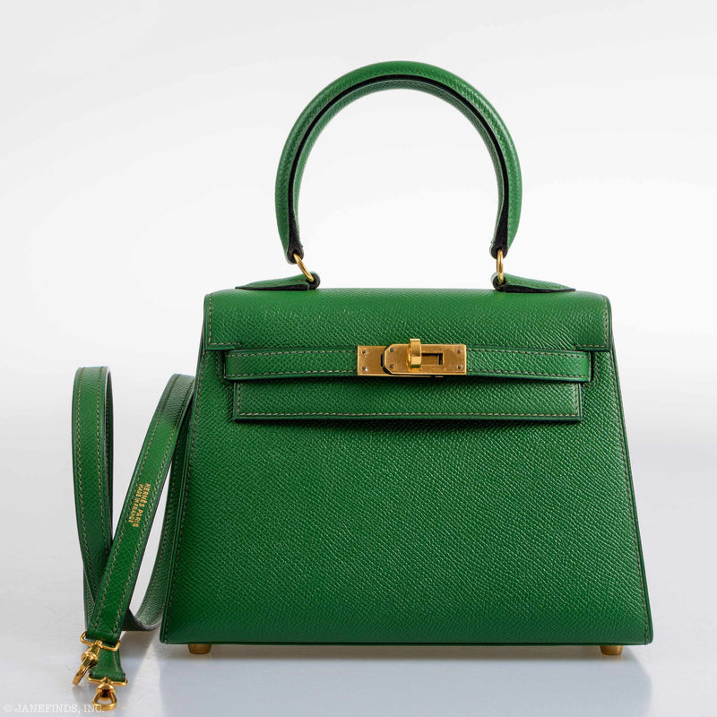 The Hermes Kelly Mini Pochette being held by hand, showcasing its compact size and top handle