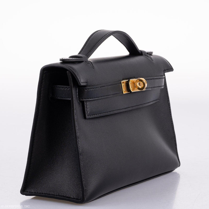 A close-up of the rolled leather top handle and its attachment point on the bag