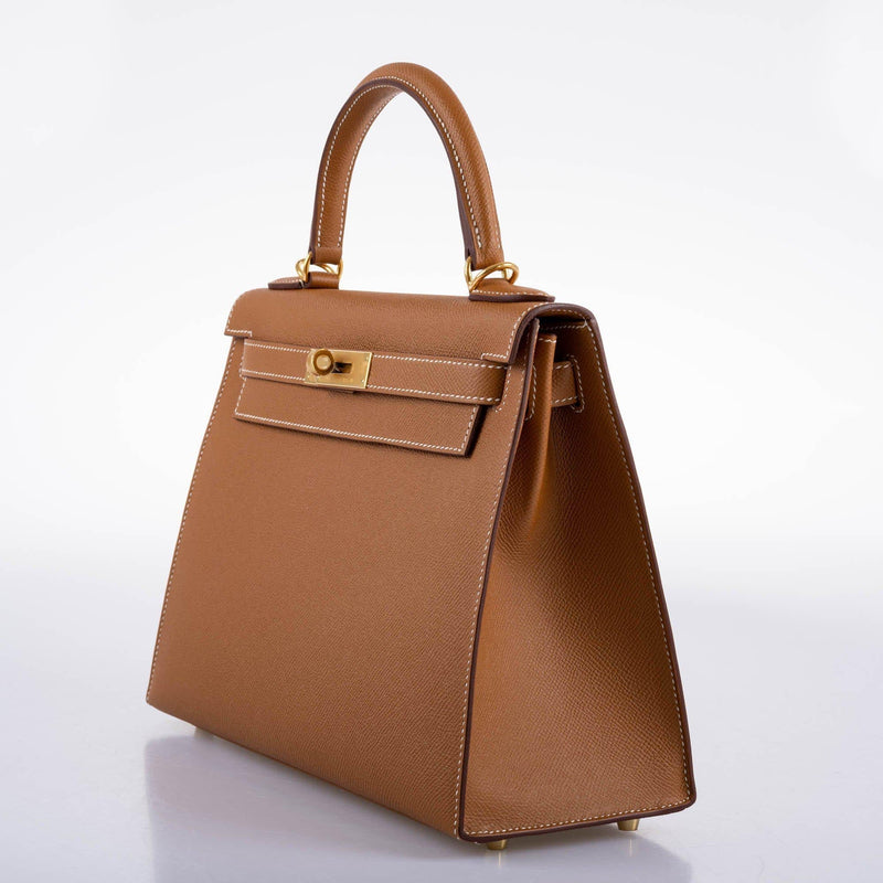 The Hermes Kelly Sellier 28 in Gold Epsom being worn on the shoulder