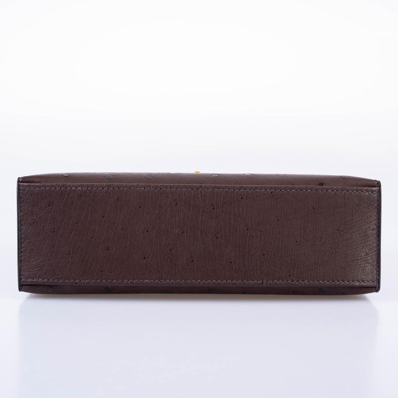 Close-up of gold turn-lock on Rouge Sellier Pochette